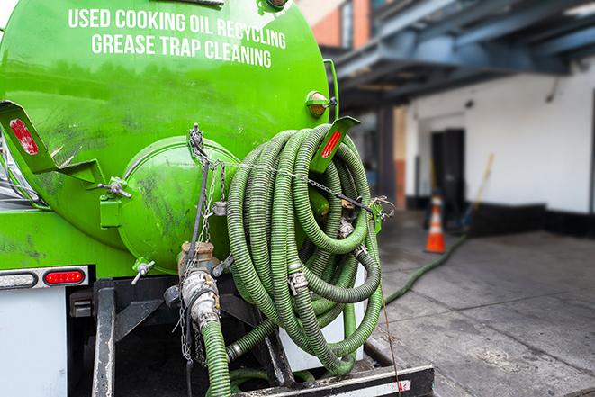 a service truck pumping grease from a restaurant's grease trap in Harlem